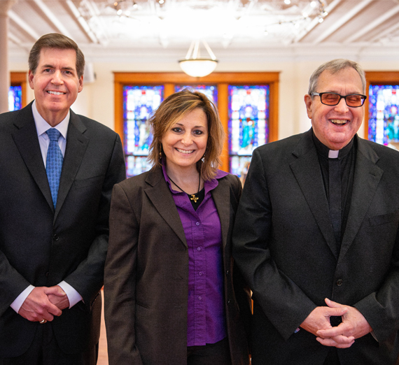 two individuals stand side by side with shovels, one wrapped in blue and the other in purple